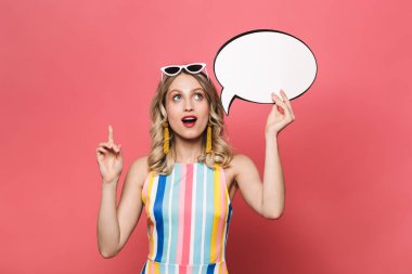 Heyecanlı genç kadın işaret konuşma kabarcık tutarak kırmızı mercan arka plan üzerinde izole poz.