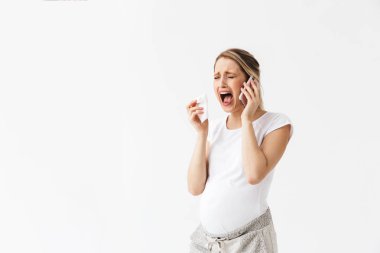 Üzgün genç hamile kadın peçete ağlamak tutarak beyaz duvar arka plan üzerinde izole poz.