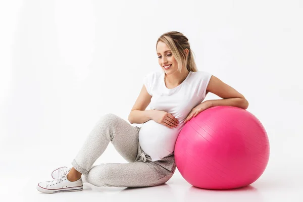 Bela jovem grávida ioga fitness mulher posando isolado sobre fundo da parede branca fazer exercícios com bola . — Fotografia de Stock
