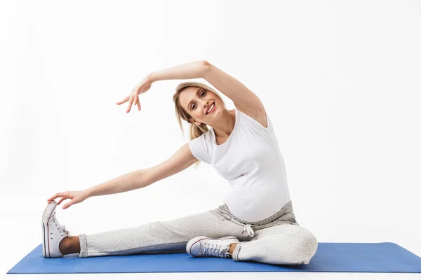 W ciąży Joga fitness kobieta pozowanie na białym tle ściany tło zrobić ćwiczenia. — Zdjęcie stockowe