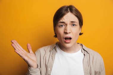 Gömlek gesturing ve kamera bakarak şaşırttı yakışıklı adam