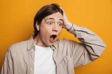 Şok yakışıklı adam gömlek başını tutarak ve uzağa bakıyor