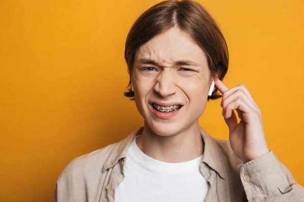 Imagen de primer plano del hombre sonriente con camisa escuchando música — Foto de Stock