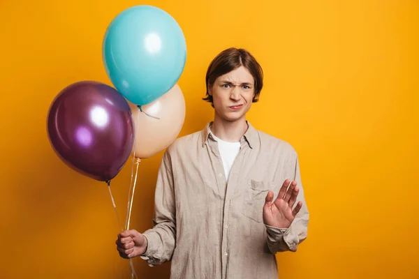 Méchant homme en chemise tenant des ballons et montrant arrêt — Photo