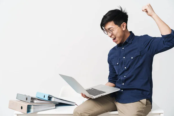 Foto di eccitato asiatico uomo 20s indossare occhiali seduto al tab — Foto Stock