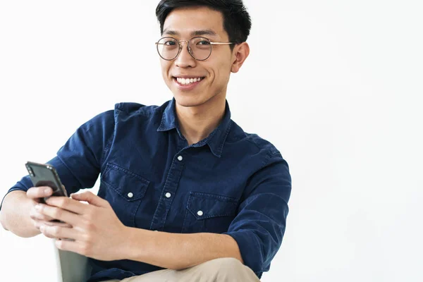 Photo of joyful chinese businessman 20s wearing eyeglasses sitti — Stock Photo, Image