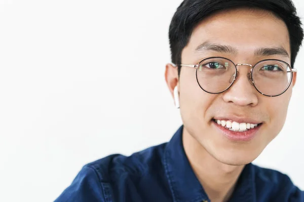 Photo closeup of content chinese man 20s wearing earpods and eye — Stock Photo, Image