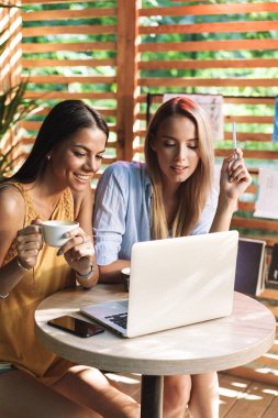 İki neşeli genç kız kapalı kafede oturan