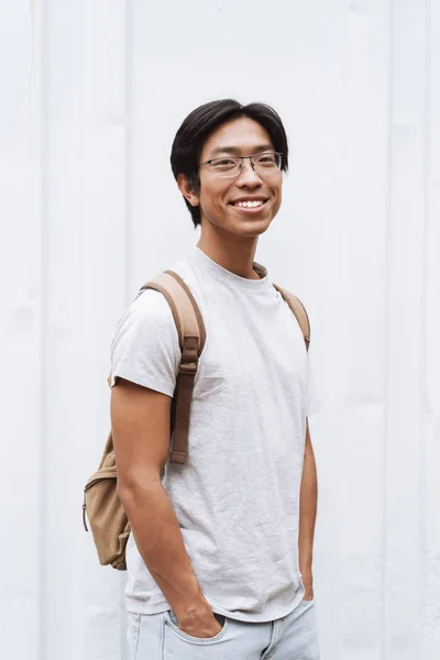 Sonriendo joven asiático hombre estudiante llevar mochila — Foto de Stock