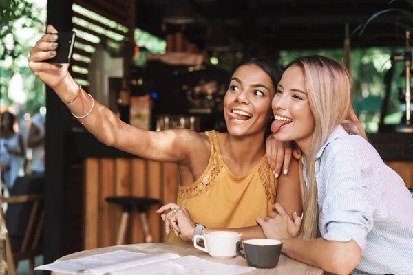 Dos jóvenes novias alegres sentadas en la mesa del café — Foto de Stock