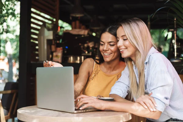 Dos jóvenes novias alegres sentadas en el café en el interior — Foto de Stock