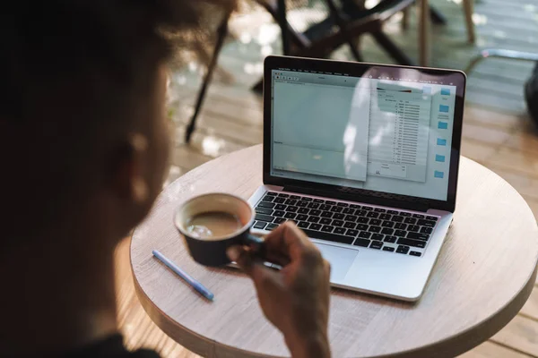 Vista posteriore di un giovane uomo africano che utilizza il computer portatile — Foto Stock