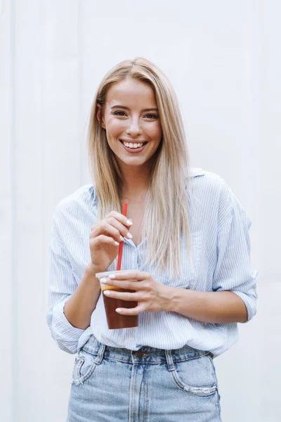 Lächelndes junges Mädchen, das im Stehen Saft trinkt — Stockfoto