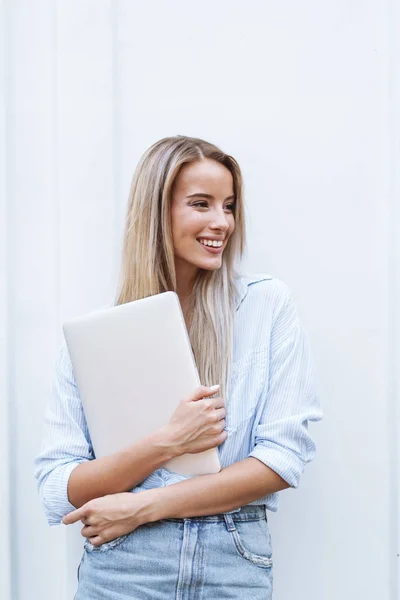 Menina sorridente bonita segurando computador portátil — Fotografia de Stock