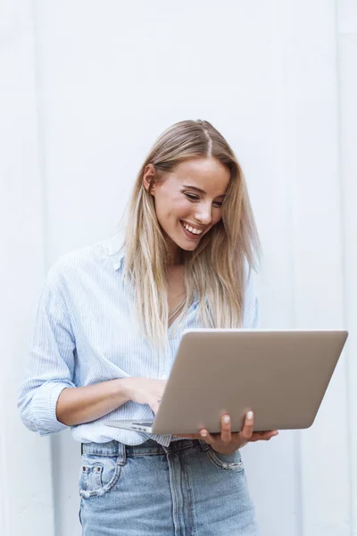 Menina sorridente bonita segurando computador portátil — Fotografia de Stock