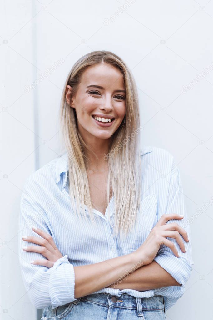 Close up of a smiling young blonde woman standing