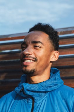 Kapüşonlu ceket giyen afrikalı genç bir adamın yakın çekim