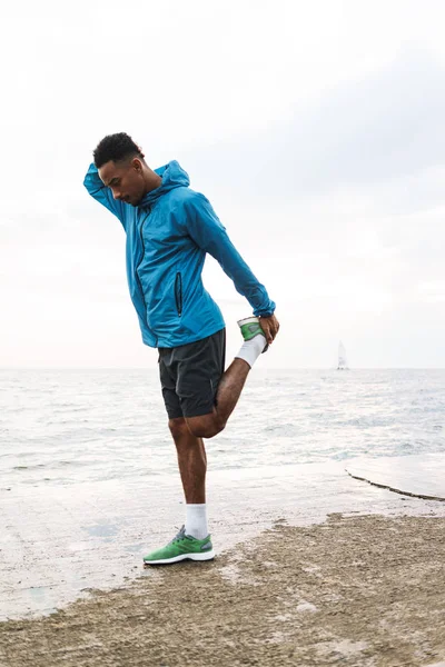 ビーチ海ウォーキングで屋外でハンサムな若いアフリカのスポーツマンは、演習を行います. — ストック写真