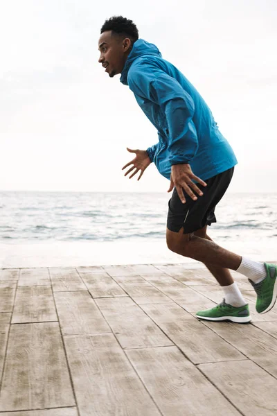 Mladý africký sportovní muž běžec venku na pláži moře běh, aby cvičení. — Stock fotografie