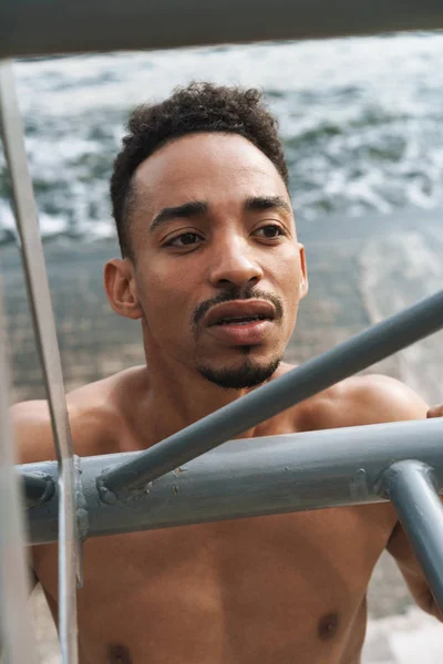 Bonito jovem homem de esportes africanos ao ar livre na praia mar andando fazer exercícios . — Fotografia de Stock