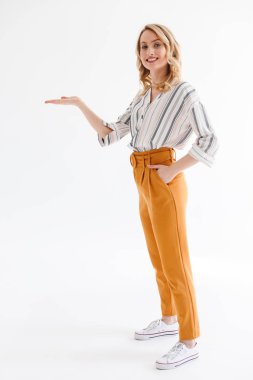 Kameraya gülümseyen ve avucunun üzerinde copyspace tutan büyüleyici genç kadının tam uzunlukta fotoğraf