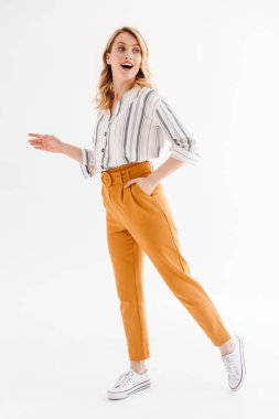 Bir kenara bakarak ve yürüyüş rahat giysiler giyen neşeli genç kadının tam uzunlukta fotoğraf