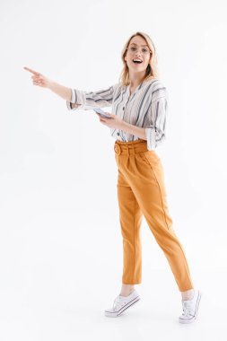 Copyspace'i işaret eden ve cep telefonu tutan gözlük takan Avrupalı kadının tam uzunlukta fotoğrafı