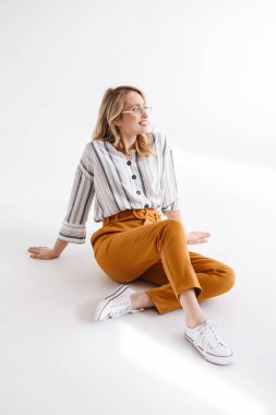 Yerde oturan ve kenara bakan gözlük takan güzel gülümseyen kadın portresi