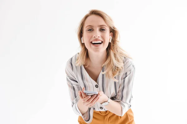 Foto de una joven mujer sonriente que usa reloj de pulsera con teléfono celular y auriculares — Foto de Stock