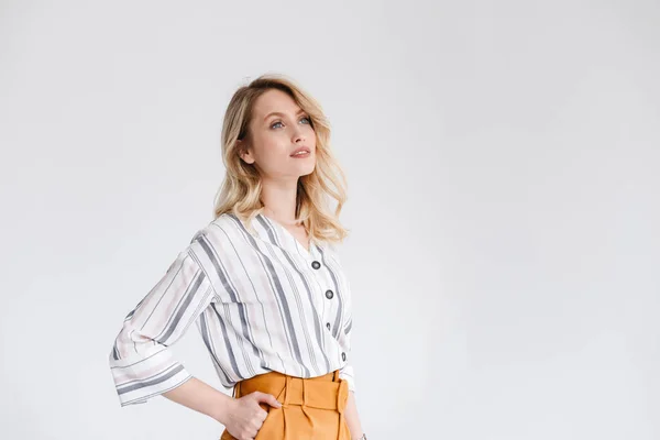 Media vuelta retrato de una mujer joven y agradable con ropa casual mirando a un lado en el copyspace con la mano en el bolsillo —  Fotos de Stock