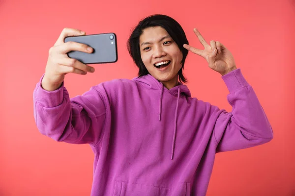 Foto de alegre asiático cara 20s vestindo sweatshirt mostrando paz s — Fotografia de Stock