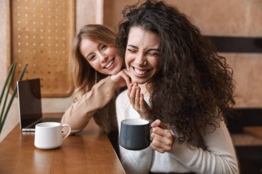 Kafede oturan iki neşeli genç kız arkadaş