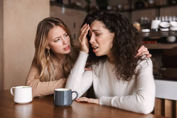Две расстроенные девушки сидят за столиком в кафе — стоковое фото