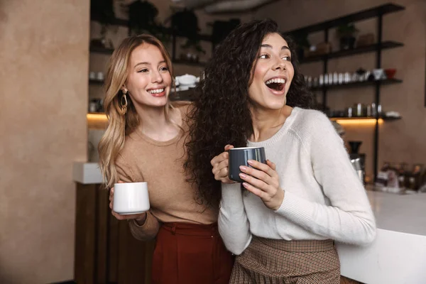 Två glada unga flickvänner som står på caféet — Stockfoto