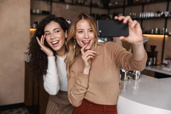 Kafede oturan heyecanlı duygusal kız arkadaşlar selfie cep telefonu çekmek. — Stok fotoğraf