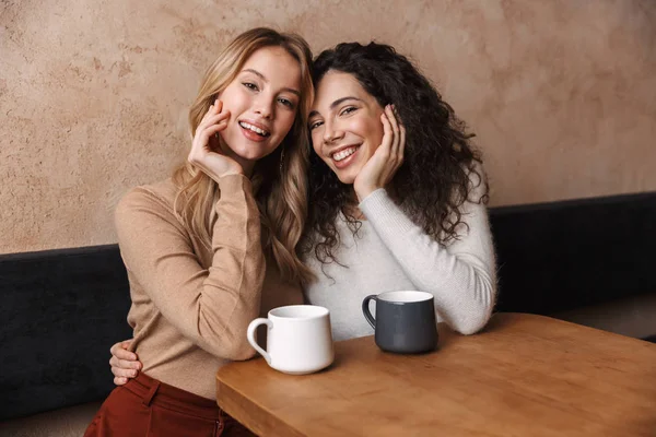 Ragazze felici amici seduti in caffè a parlare con l'altro bere tè o caffè . — Foto Stock
