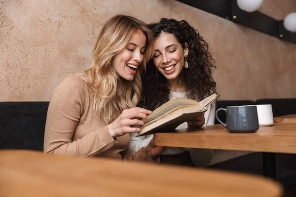 예쁜 여자 친구 앉아 에 카페 마시는 커피 독서 책. — 스톡 사진