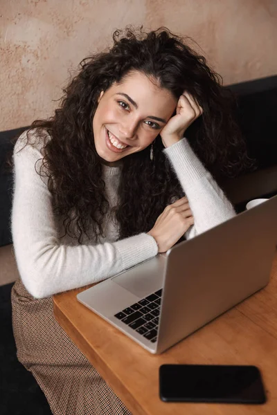 Pretty happy girl sitting in cafe using laptop computer. — Stock Photo, Image