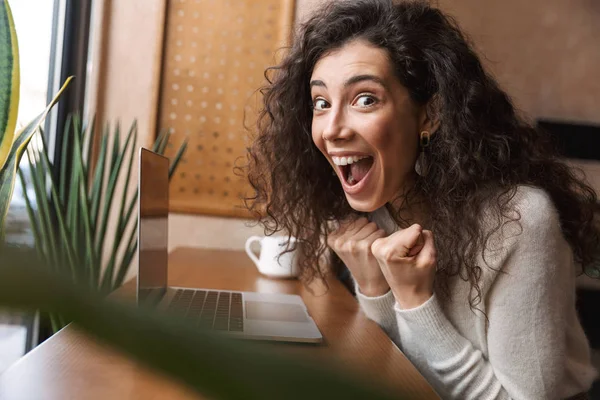 Emotivo scioccato ragazza seduta in caffè utilizzando computer portatile fare gesto vincitore . — Foto Stock