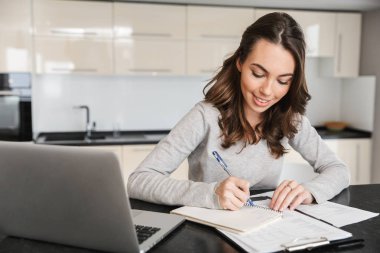 Dizüstü bilgisayarda çalışan çekici genç kadın