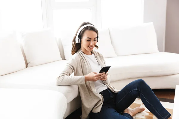 Sorrindo menina bonita relaxando em um sofá em casa — Fotografia de Stock