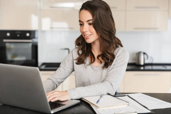 Attraktive junge Frau, die am Laptop arbeitet — Stockfoto