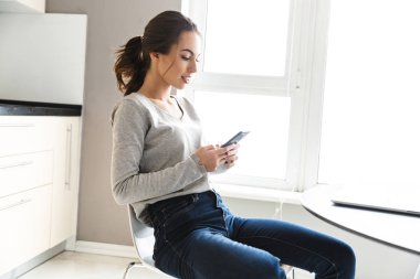 Dizüstü bilgisayarüzerinde çalışan çekici gülümseyen genç kadın