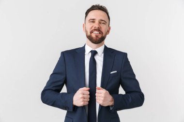 Yakışıklı genç işadamı beyaz duvar arka plan üzerinde izole poz.