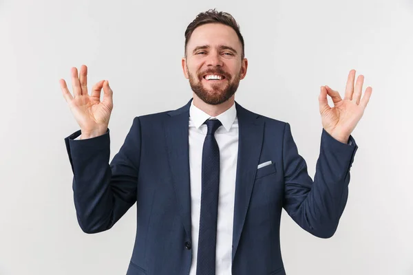 Empresário feliz posando isolado sobre fundo da parede branca fazer gesto ok . — Fotografia de Stock