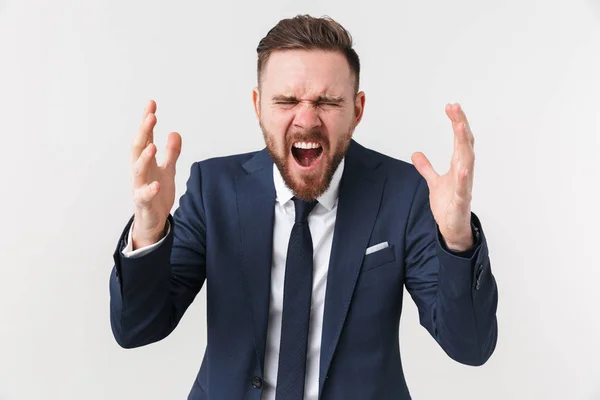 Gritando sorprendido joven empresario posando aislado sobre fondo blanco de la pared . — Foto de Stock