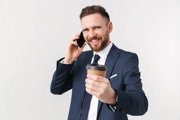 Mutlu işadamı beyaz duvar arka plan üzerinde telefonla konuşurken kahve içme izole poz. — Stok fotoğraf
