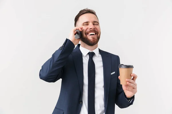Homme d'affaires heureux posant isolé sur fond de mur blanc boire du café parler par téléphone . — Photo