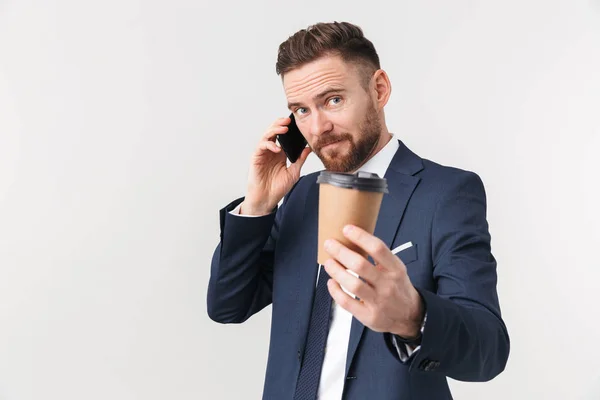 Empresário posando isolado sobre fundo da parede branca bebendo café falando por telefone . — Fotografia de Stock