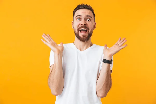 Hombre excitado posando aislado sobre fondo amarillo de pared . — Foto de Stock